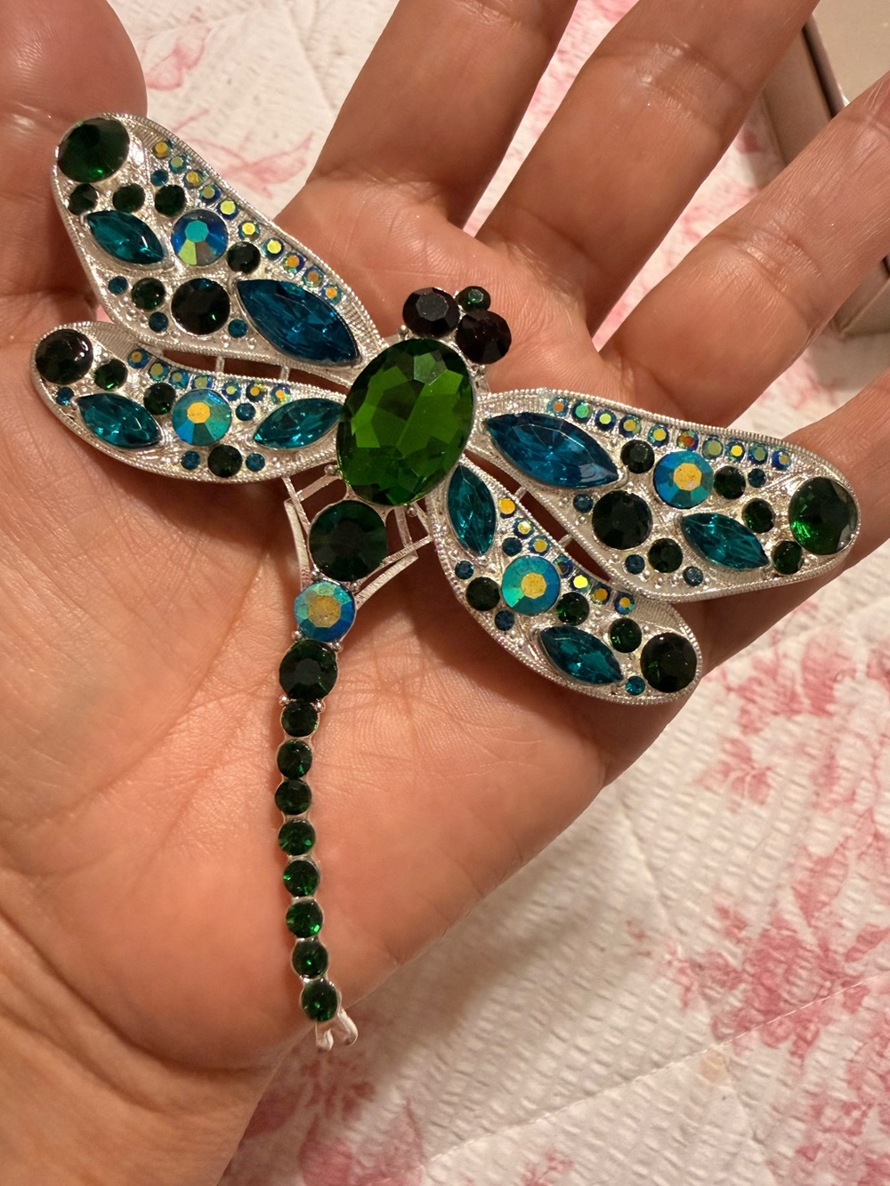 silver-tone dragonfly brooch featuring green and blue rhinestones